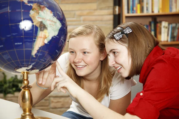 Jugendliche in der Bibliothek schauen auf Globus — Stockfoto