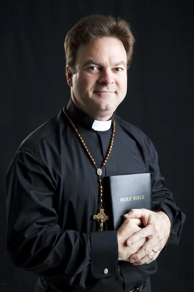 Priester mit Rosenkranz und Bibel — Stockfoto