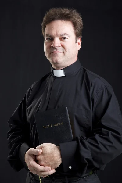 Торжественный священник с Библией — стоковое фото