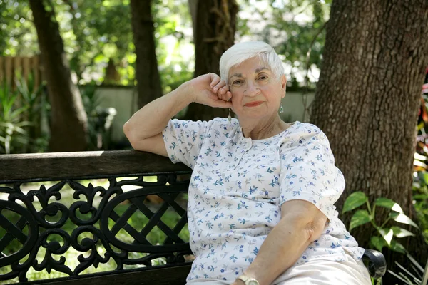 Senior dam avkopplande i park — Stockfoto