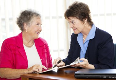 Mature Businesswomen Discuss Contract clipart