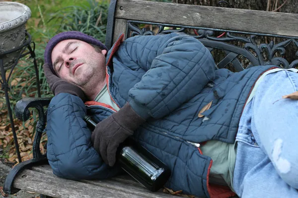 Bezdomny - na ławce w parku — Zdjęcie stockowe