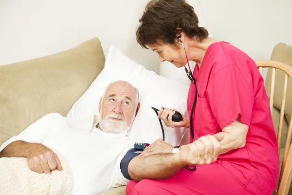 Home Salud Enfermera toma presión arterial — Foto de Stock