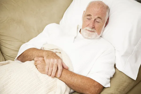 Starší muž spí na gauči — Stock fotografie