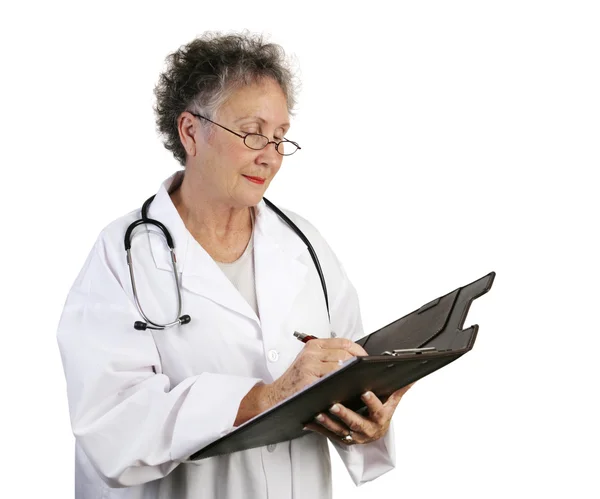 Зрелая женщина-доктор делает заметки — стоковое фото