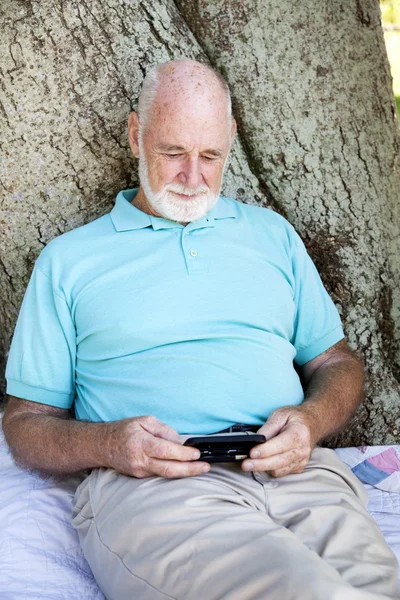 Senior man met slimme telefoon — Stockfoto