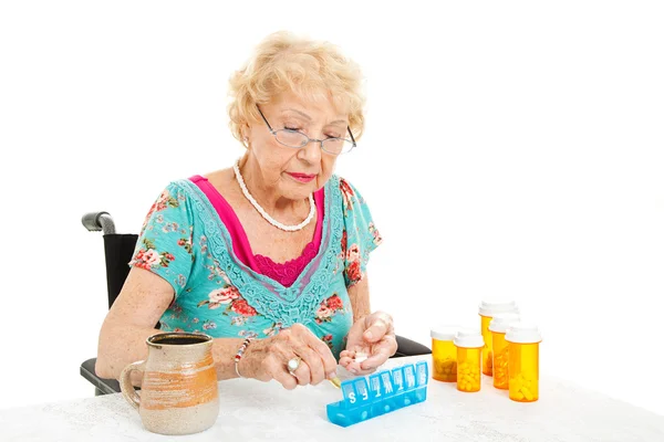 Mulher em cadeira de rodas conta pílulas — Fotografia de Stock