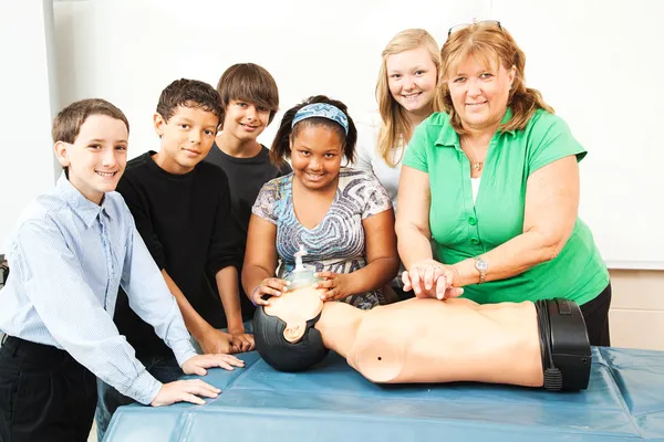 Insegnante con classe CPR e manichino — Foto Stock