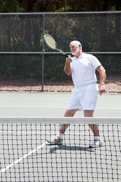 Пенсионер играет в теннис — стоковое фото