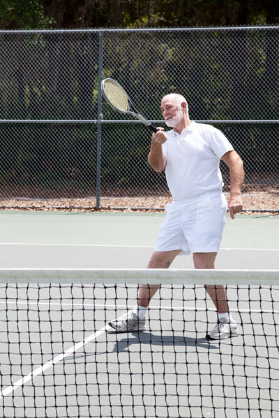 Active senior man playing a game of tennis.
