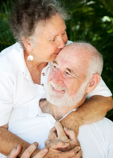 Старшая пара - поцелуи для мужа — стоковое фото