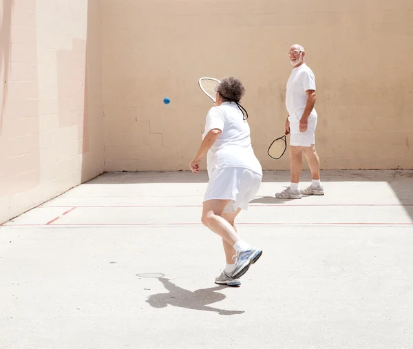 Старшая пара, играющая в ракетбол — стоковое фото