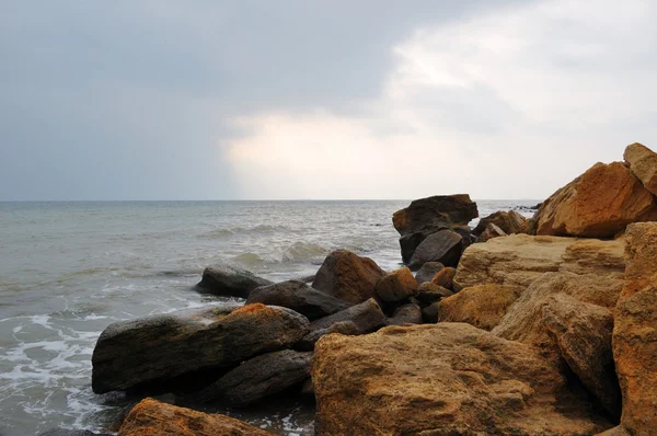 stock image Beautiful sundown at rocky beach. Water in motion blur.