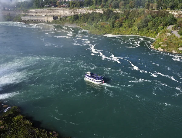 A boat in a river next to Niagara falls — Stock Photo, Image