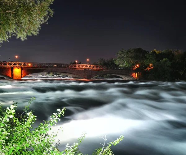 Berg rivier met bridge op het moment van de nacht — Stockfoto