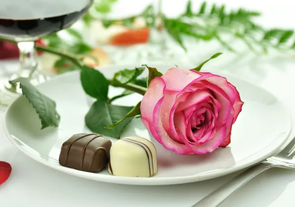 Романтический ужин с розой на тарелке — стоковое фото