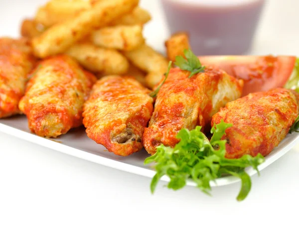 Hot chicken wings with fried potatoes and sauce — Stock Photo, Image