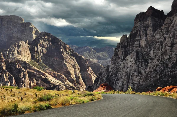 Дорога в горы и впечатляющее небо — стоковое фото