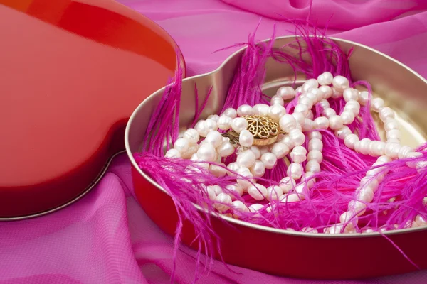 Pearls in a heart-shaped box on a pink background — Stock Photo, Image