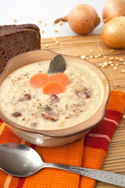 Гороховый суп, ложка и лук — стоковое фото