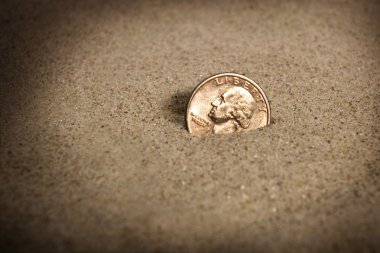 Lost Dollar Coin In Sand On The Beach Concept clipart