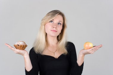 Girl choose between an apple and a cake clipart