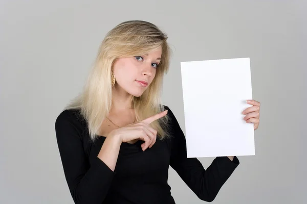 Ung flicka visar ett tomt pappersark Stockbild