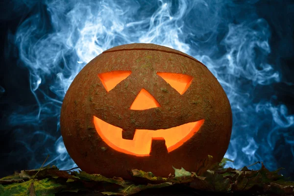 Halloween pumpa på blad med blå rök — Stockfoto
