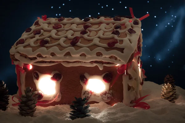 Пряничный домик зимой со звездами на заднем плане — стоковое фото