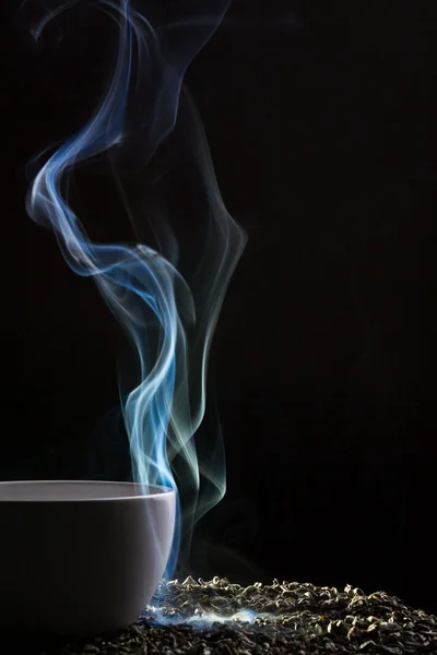 Çay ve mavi siyah arka plan üzerinde duman — Stok fotoğraf