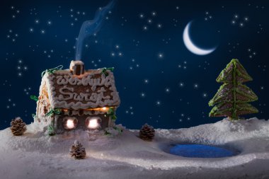 Gingerbread lodge with light from the window in winter clipart