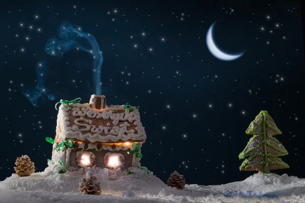 Snowy gingerbread cottage with stars at the lake — Stock Photo, Image