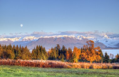 Moon over the Kenai mountains in fall clipart