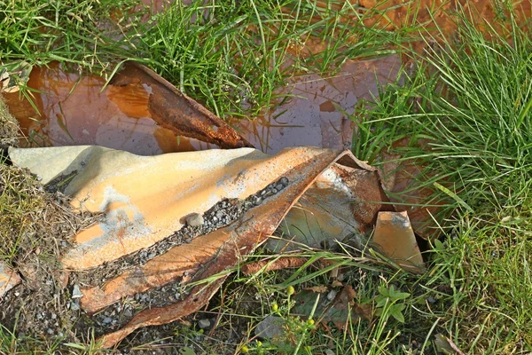 Broken metal culvert with rusty water — Stock Photo, Image