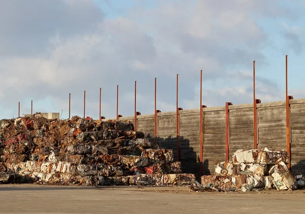 Tampa de metal por uma cerca de madeira — Fotografia de Stock