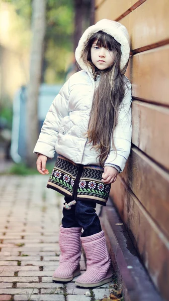 Roztomilé dítě dívka s dlouhými tmavými vlasy pózy venku — Stock fotografie