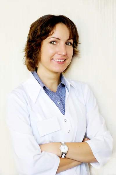 Portrét ženského lékaře proti bílé zdi — Stock fotografie
