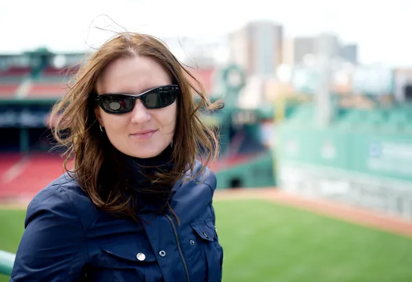 Молодая женщина в солнечных очках посещает бейсбольный парк — стоковое фото
