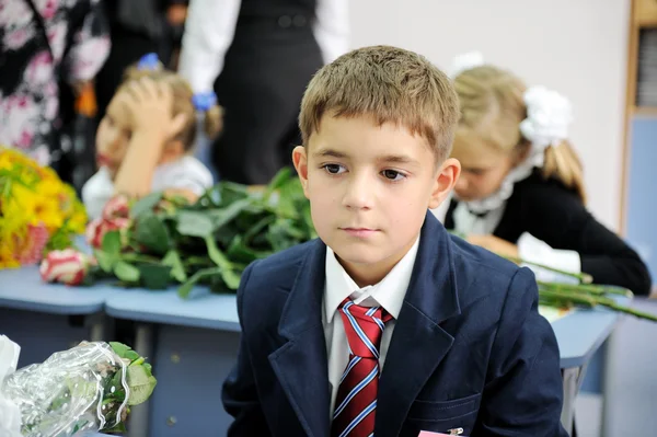 Retrato de menino do primeiro ano sentado em sua mesa — Fotografia de Stock