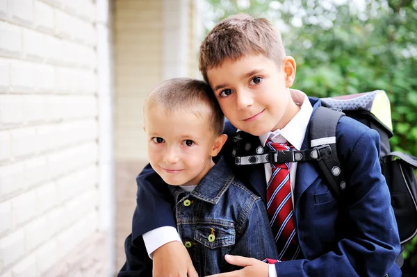 Хлопчик-першокласник обіймає свого молодшого брата — стокове фото