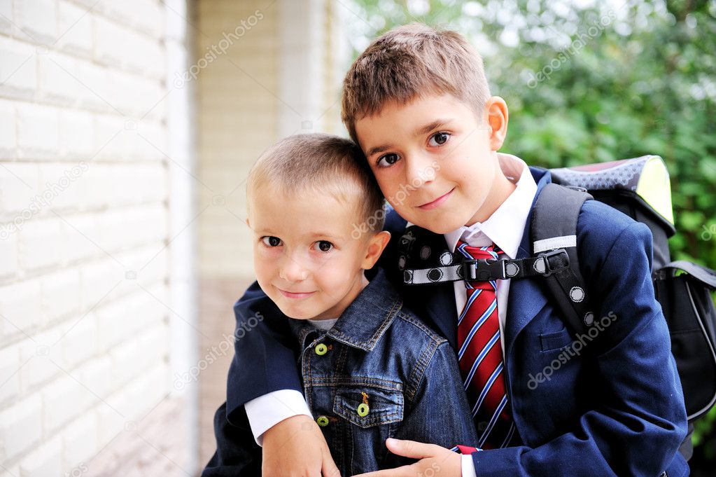 First-grader boy hugs his younger brother