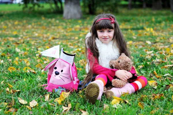Linda niña con abrigo de piel en el bosque de otoño — Foto de Stock