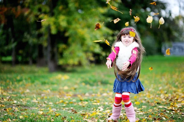 Nettes kleines Mädchen mit Pelzmantel im herbstlichen Wald — Stockfoto