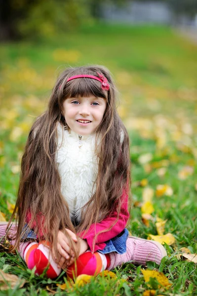 Милая маленькая девочка в шубе в осеннем лесу — стоковое фото
