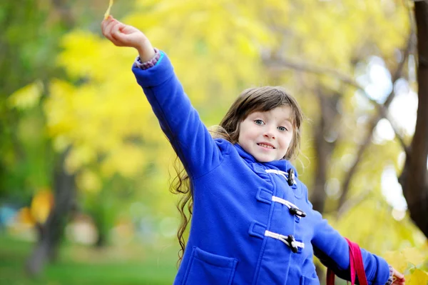 Porträtt av leende liten flicka med gula blad — Stockfoto