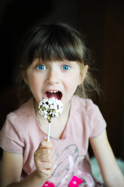 Grappige kind meisje tonen een marshmallow cake — Stok fotoğraf