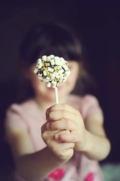 Ragazza divertente bambino mostrando una torta di marshmallow — Foto Stock