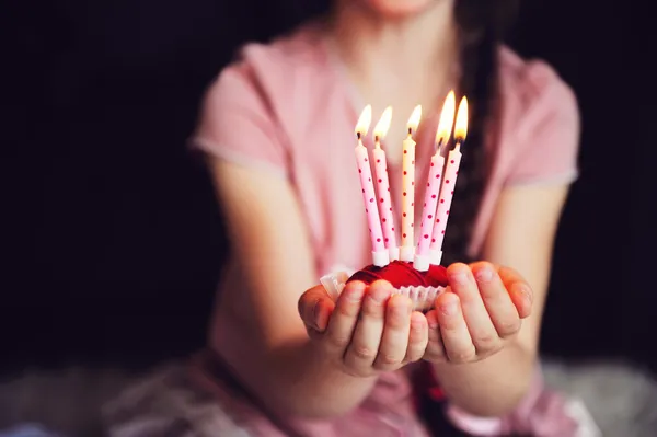 Niña sosteniendo un cupcake con cinco velas — Foto de Stock