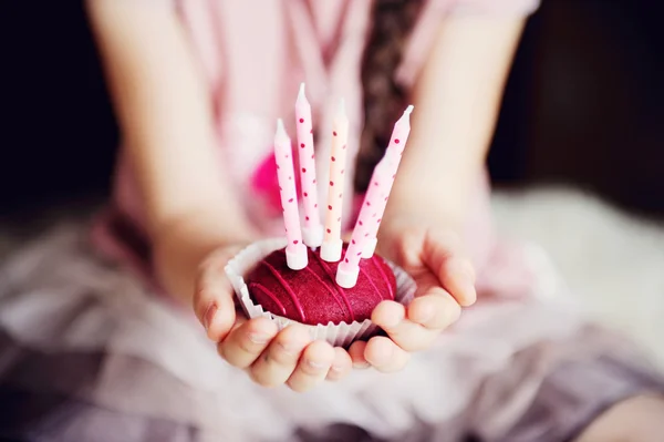 Child girl holding a cupcake with five candles — Stock Photo, Image
