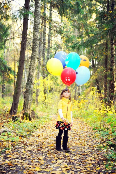 Gyermek lány léggömbökkel őszi erdő — Stock Fotó
